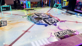 Arcade game with colorful lights and branding on a table